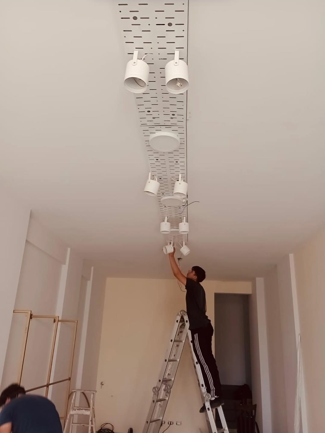 Instalação do sistema de iluminação técnica durante a reforma da loja