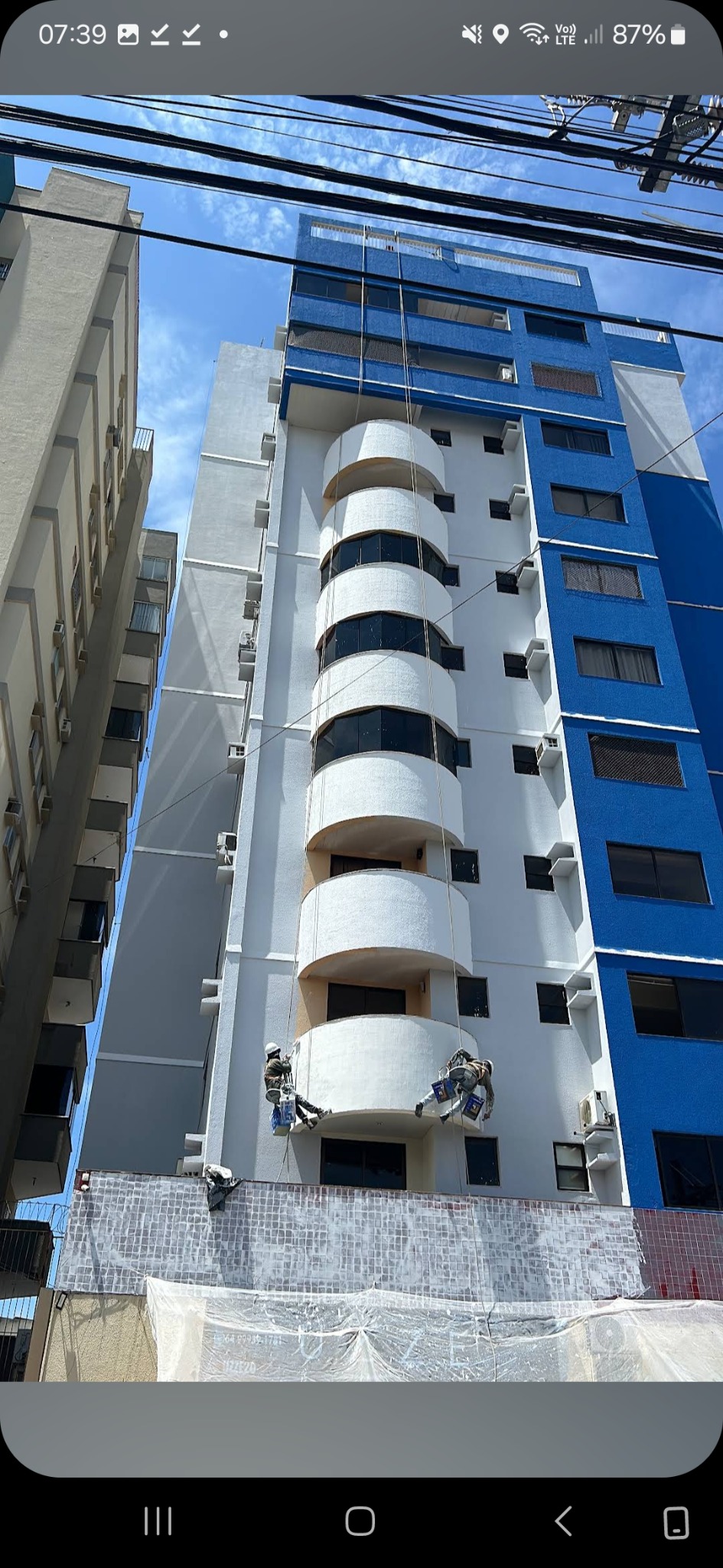 Equipe da CMG realizando recuperação e pintura de fachada por acesso por cordas